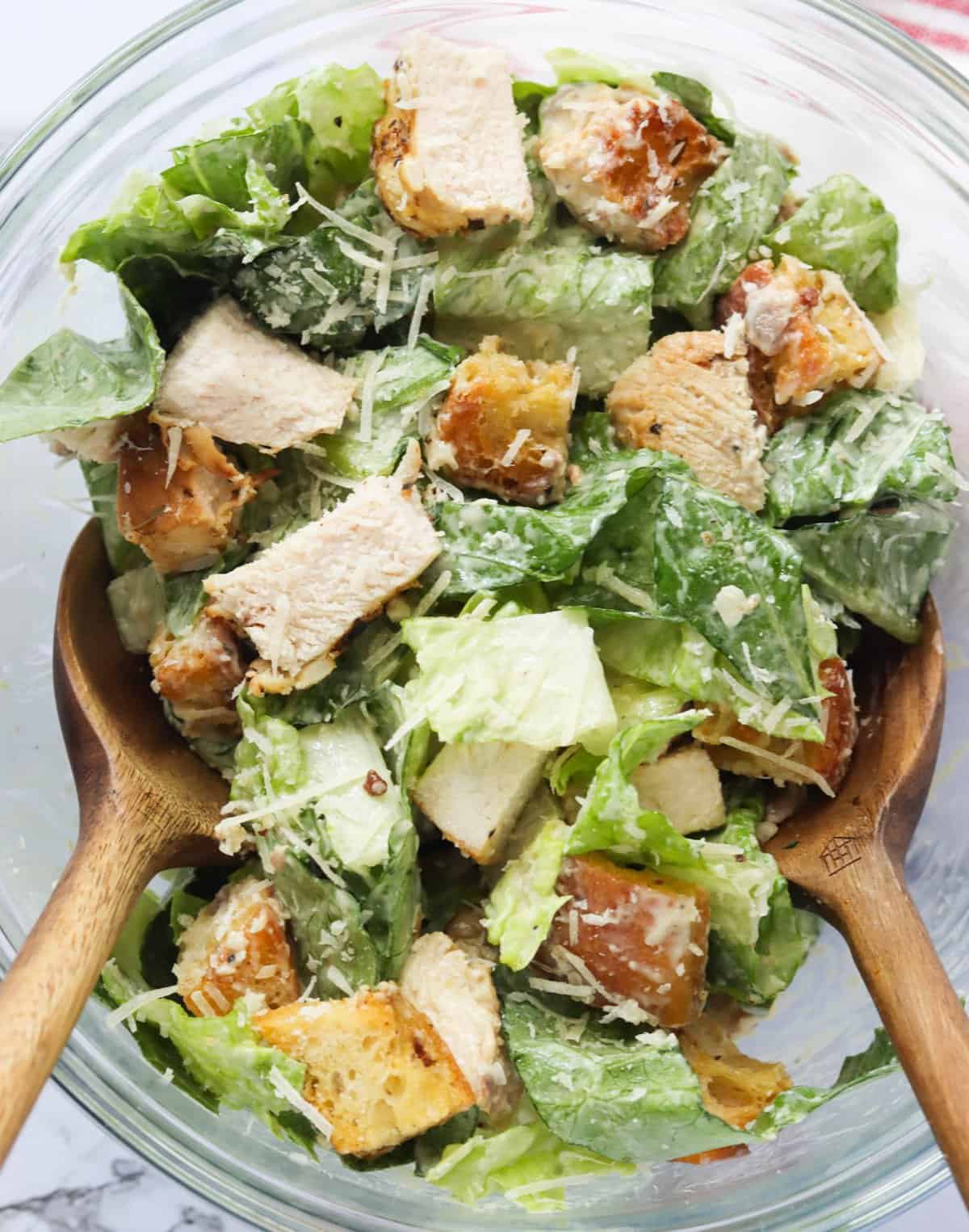 Tossing the the chicken caesar salad