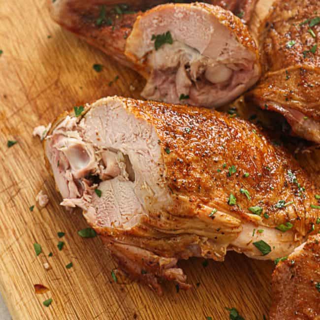 Sliced smoked turkey leg on a chopping board.