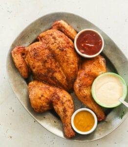 Smoked Spatchcock Chicken with traditional, white, and mustard BBQ sauce