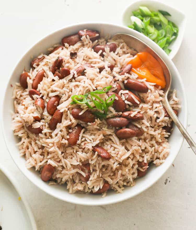 Jamaican rice and peas with green onions toppings on a bowl