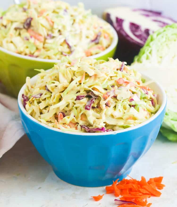 Two Bowls of Easy Coleslaw with Sliced Cabbages in the Background