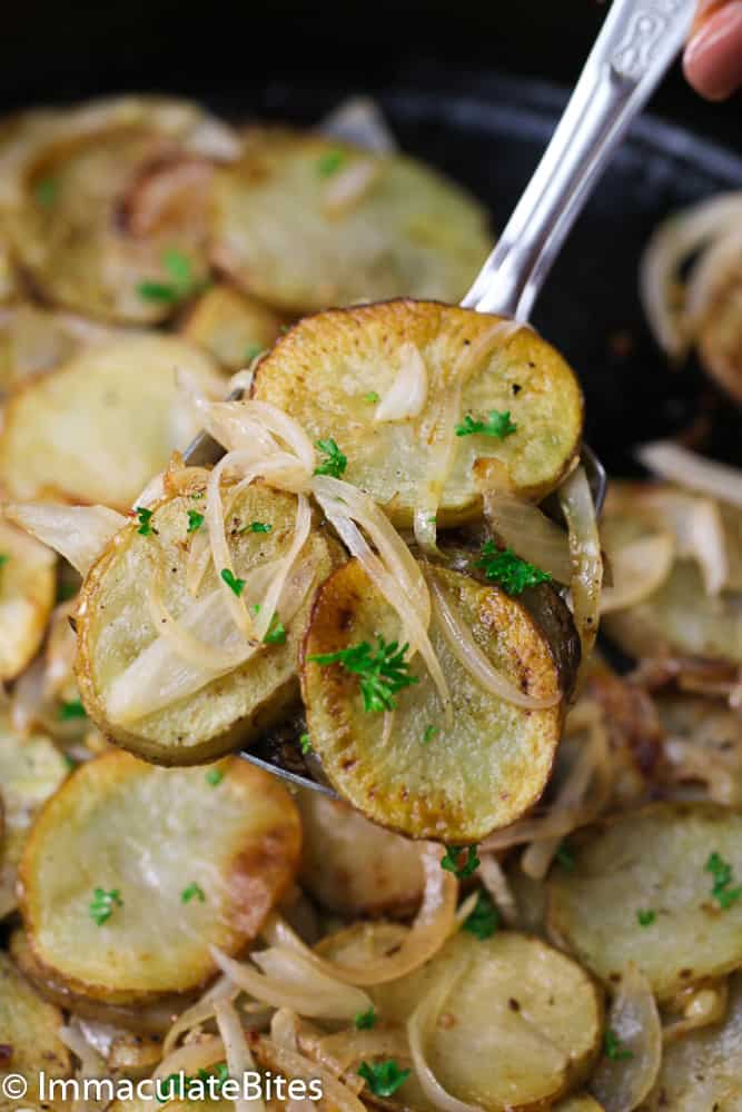 cooked potatoes and onions on a serving spoon
