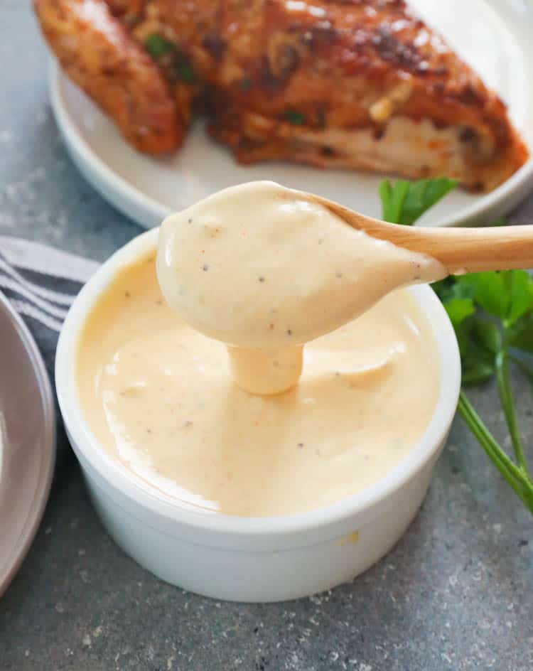 White BBQ Sauce on wooden spoon