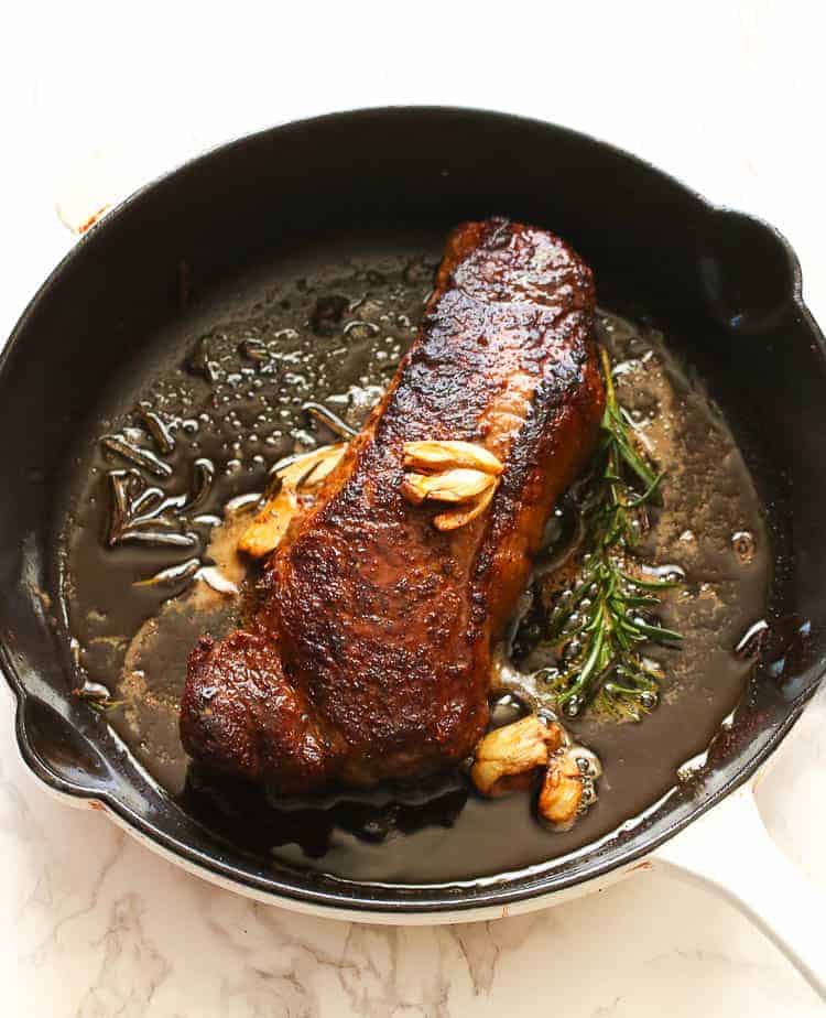 Pan Seared Oven Roasted Steak with Rosemary Sprig in a Skillet