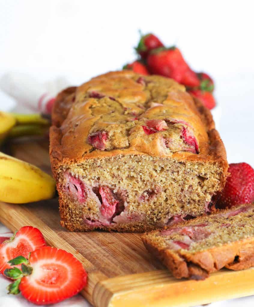 Sliced Strawberry Banana Bread with Strawberries and Banana in the Background