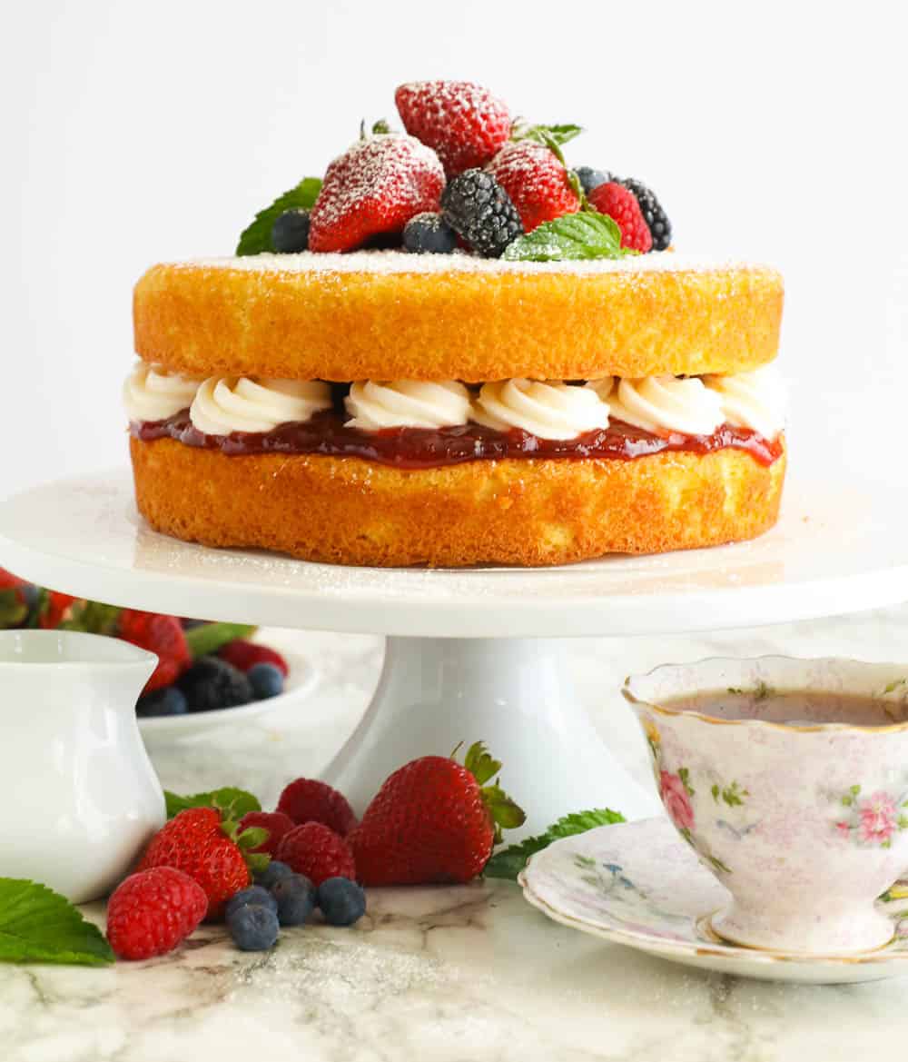 A Full Shot of Victorian Sponge Cake Topped with Berries and Served with Coffee
