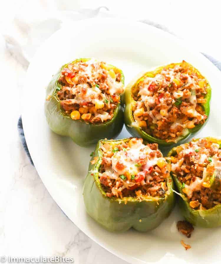 4 pieces of stuffed green bell peppers on a white plate