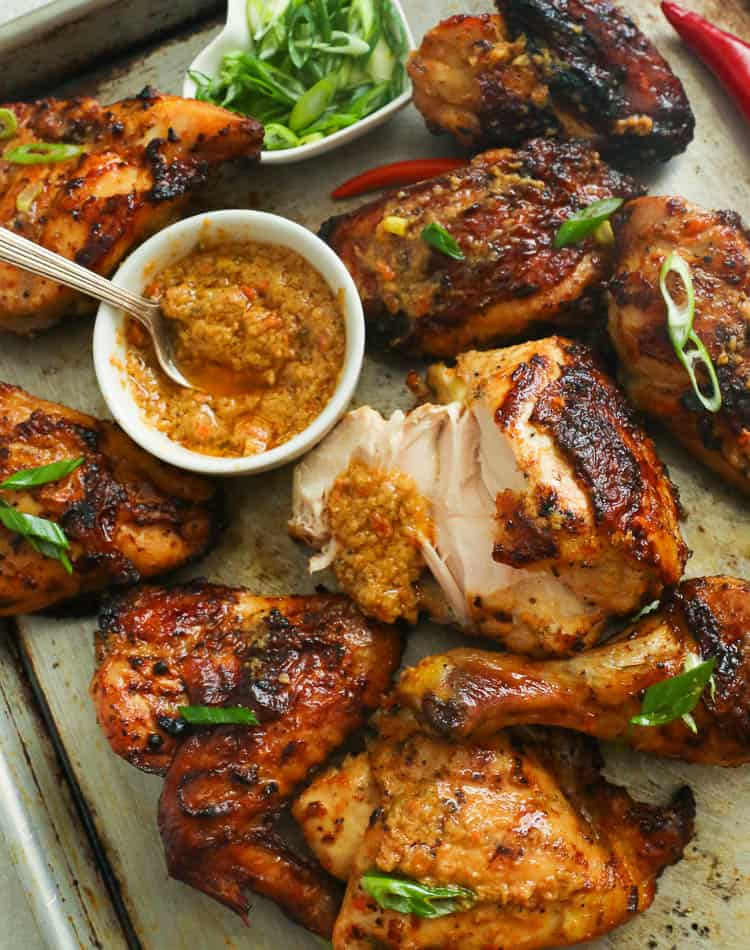 Peri peri chicken on a baking pan with extra sauce