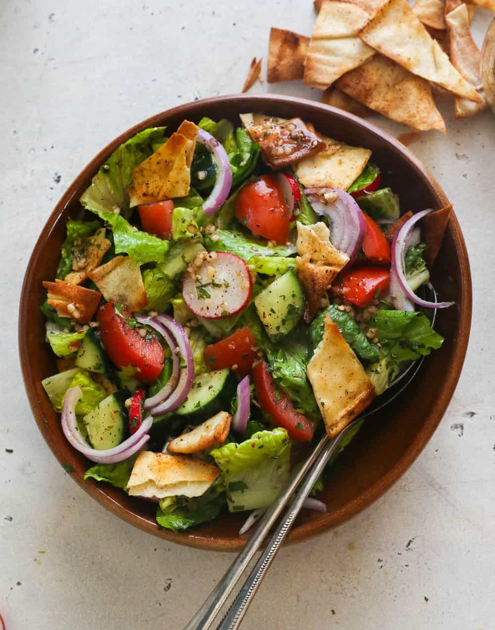 Fattoush Salad in a Brown Bowl with Serving Spoon