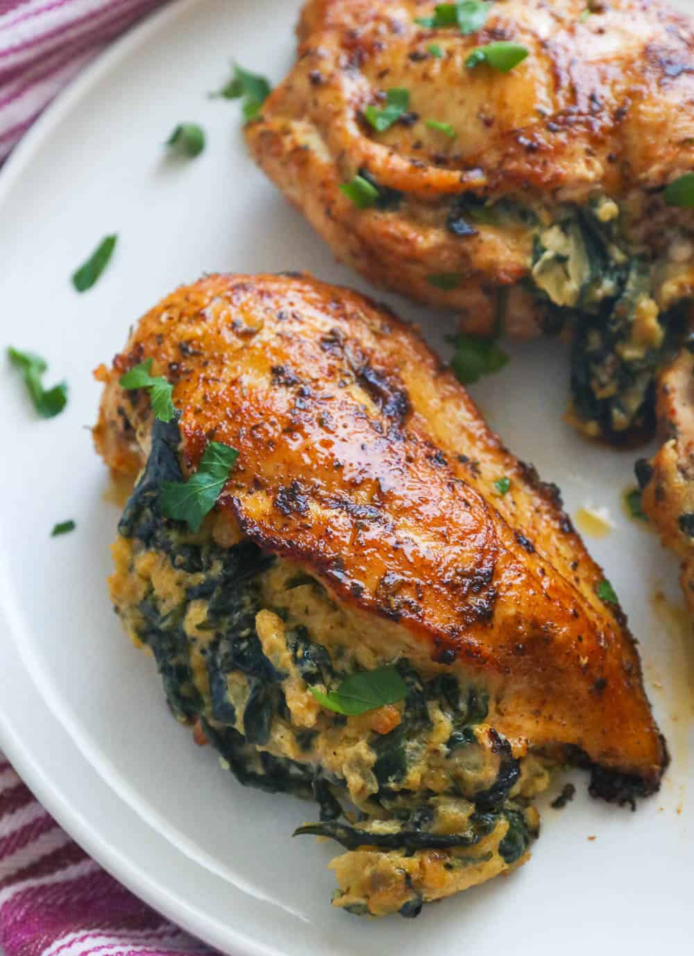 Baked Spinach Stuffed Chicken Breasts on a white plate