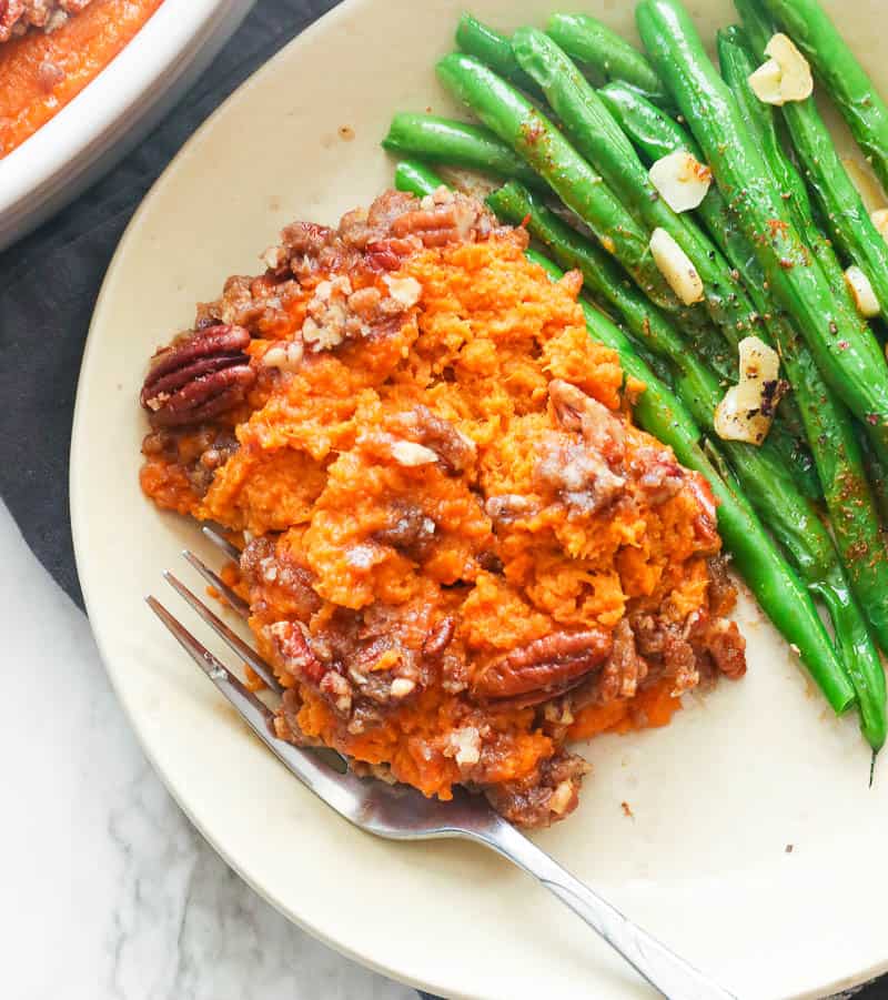 A Serving of Sweet Potato Casserole topped with Pecans and Green Beans on the Side