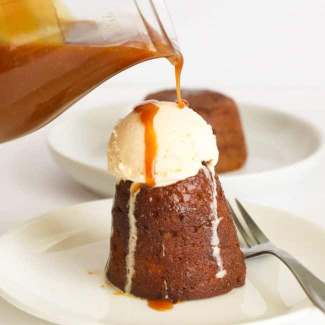 Pouring butterscotch sauce on a pudding