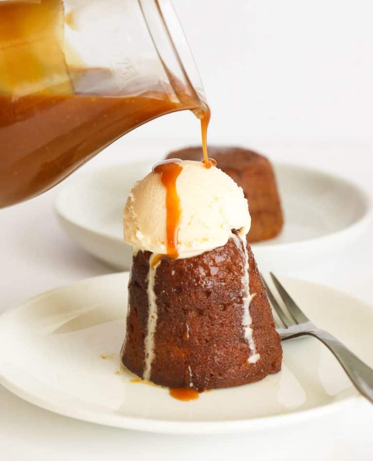 Pouring butterscotch sauce on a pudding
