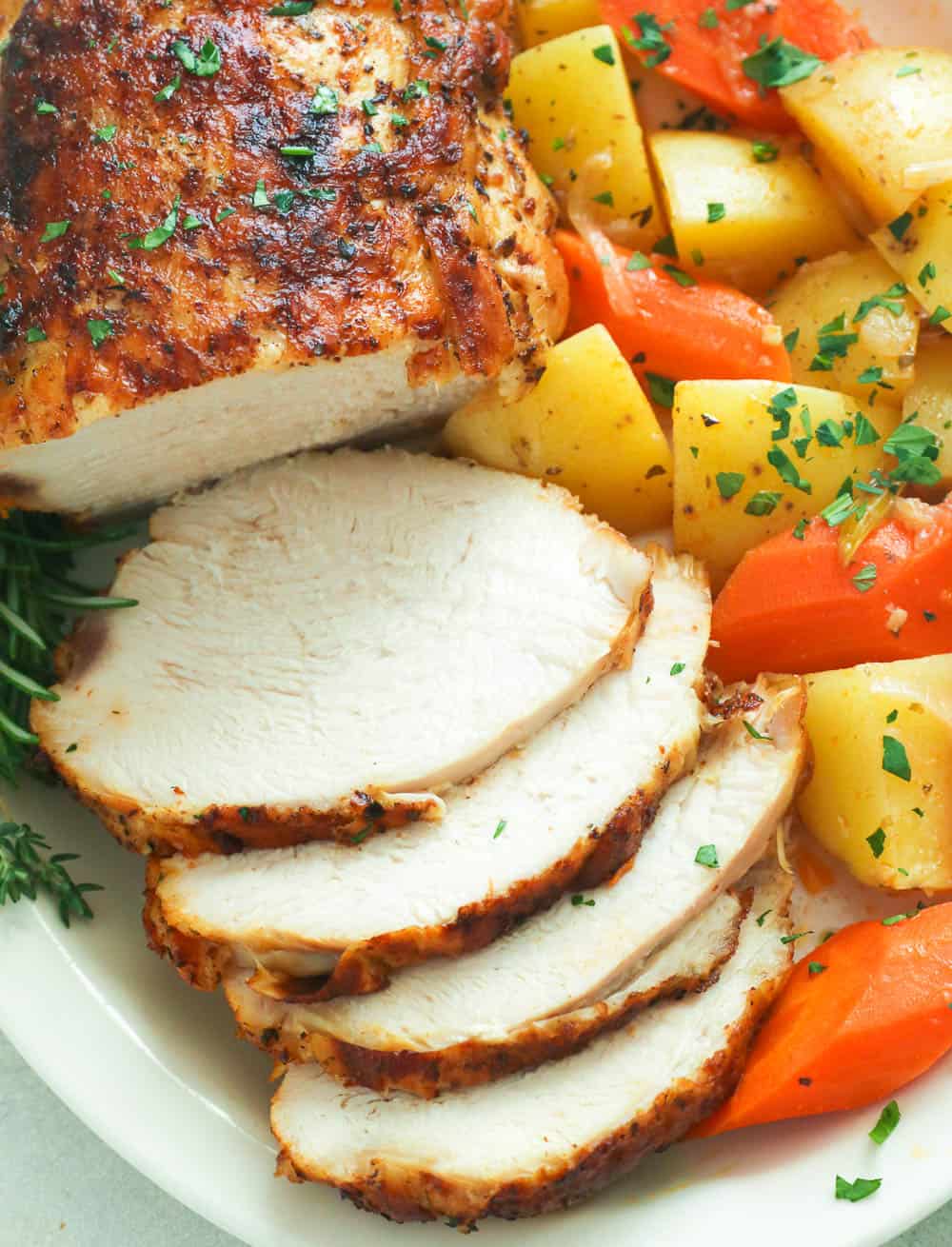 Sliced instant pot turkey breast with roasted carrots and potatoes