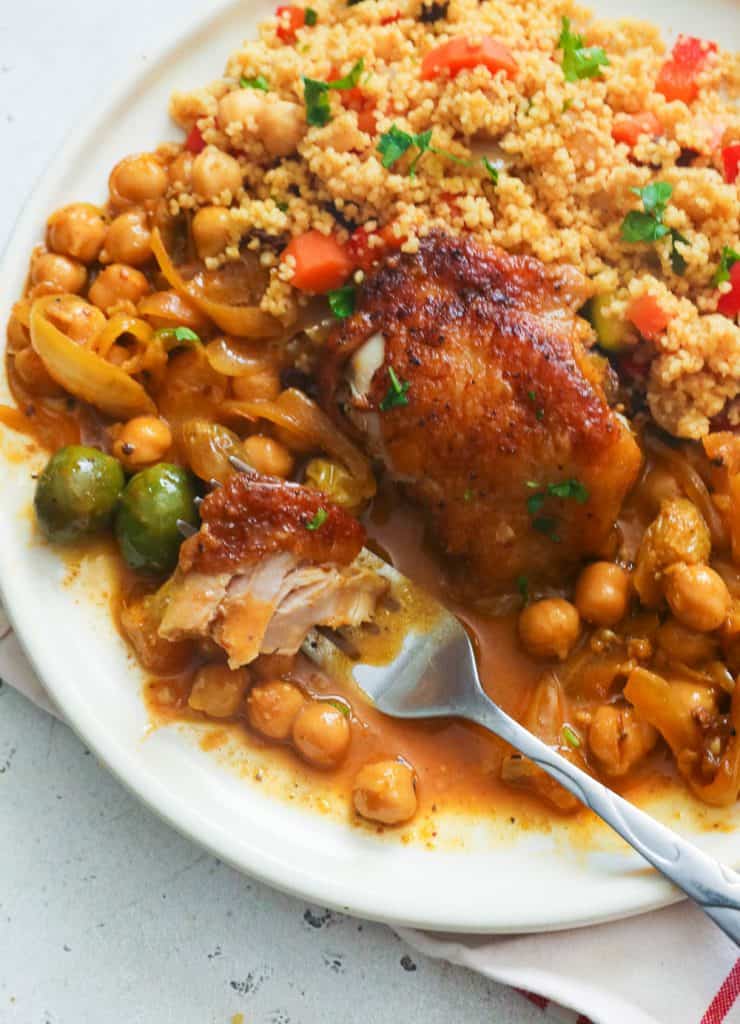 Chicken Tagine Served with Couscous on a White Plate