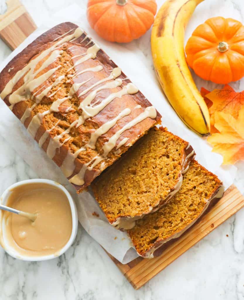 Sliced pumpkin banana bread drizzled with a luscious sauce