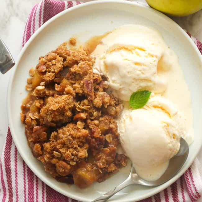 Enjoying a slice of apple crisp with vanilla ice cream.