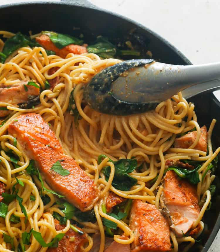 Cajun salmon pasta in a skillet with spinach