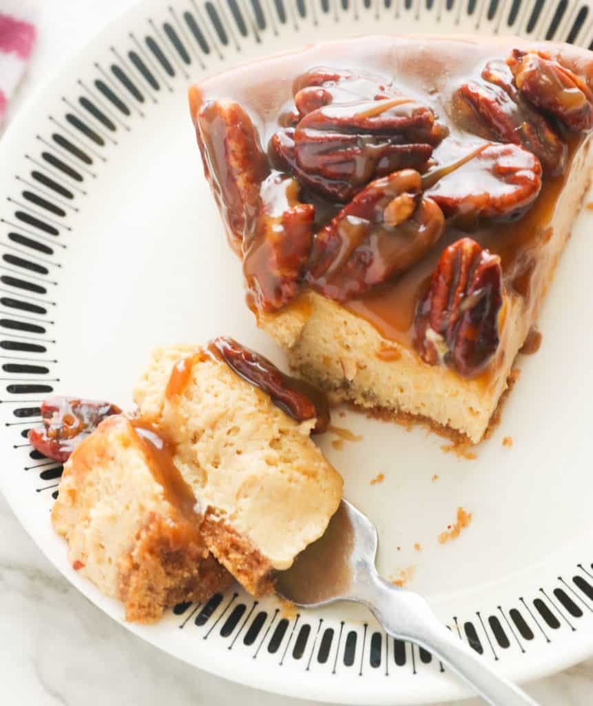 A slice of pecan cheesecake on a white plate