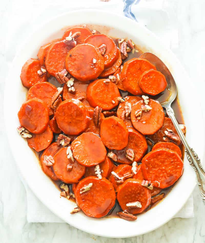 Candied Yams in a Platter topped with Sliced Pecans