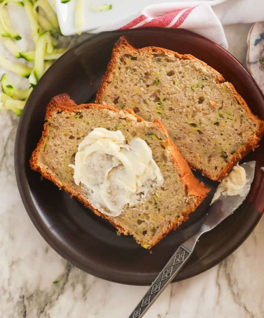 Slices of banana zucchini bread slathered with butter