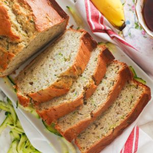 Sliced Banana Zucchini Bread with grated zucchini and bananas in the background