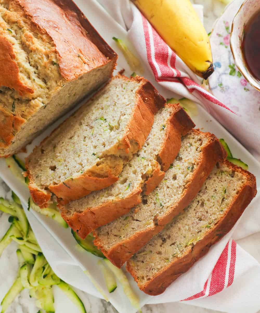 Sliced Banana Zucchini Bread with grated zucchini and bananas in the background