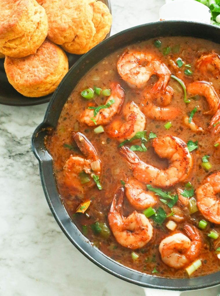 Shrimp gumbo in a skillet served with biscuits