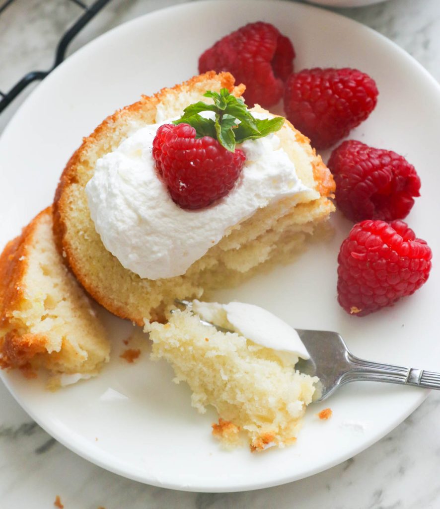 Milk cake topped with whipped cream and raspberries