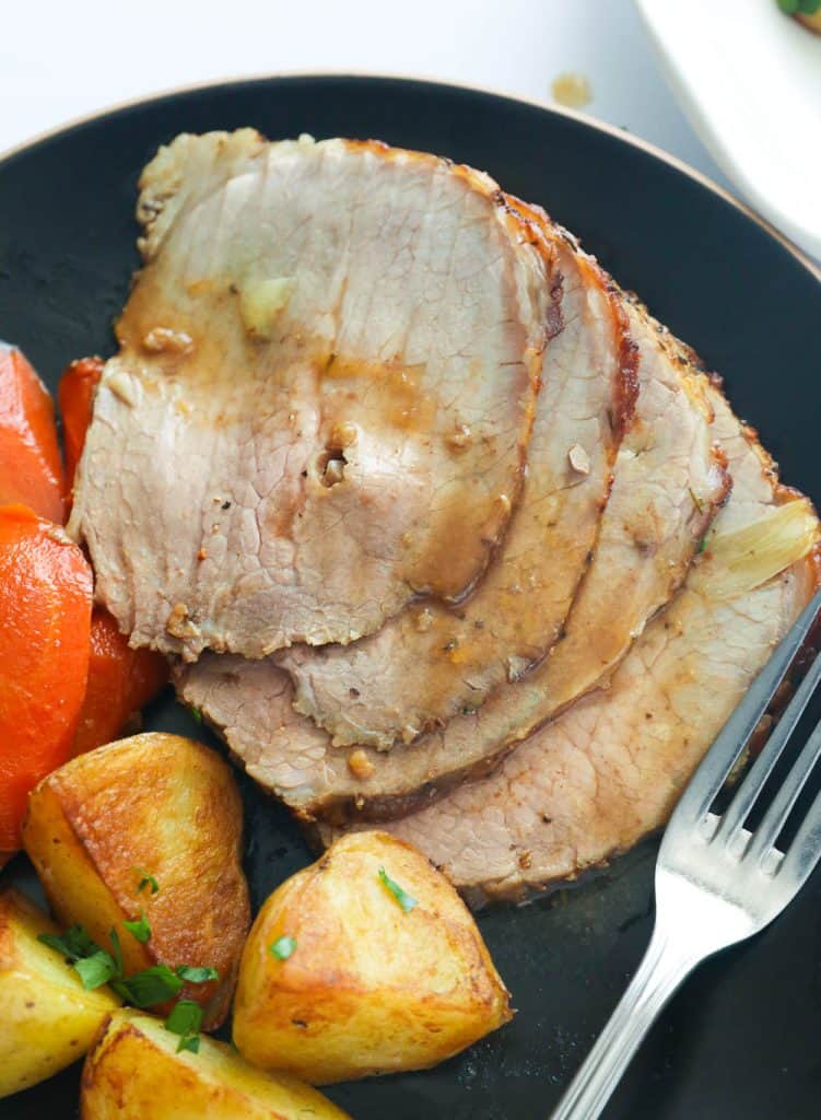 A Plate of Roast Beef Served with Homemade Sauce, Carrots, and Potatoes