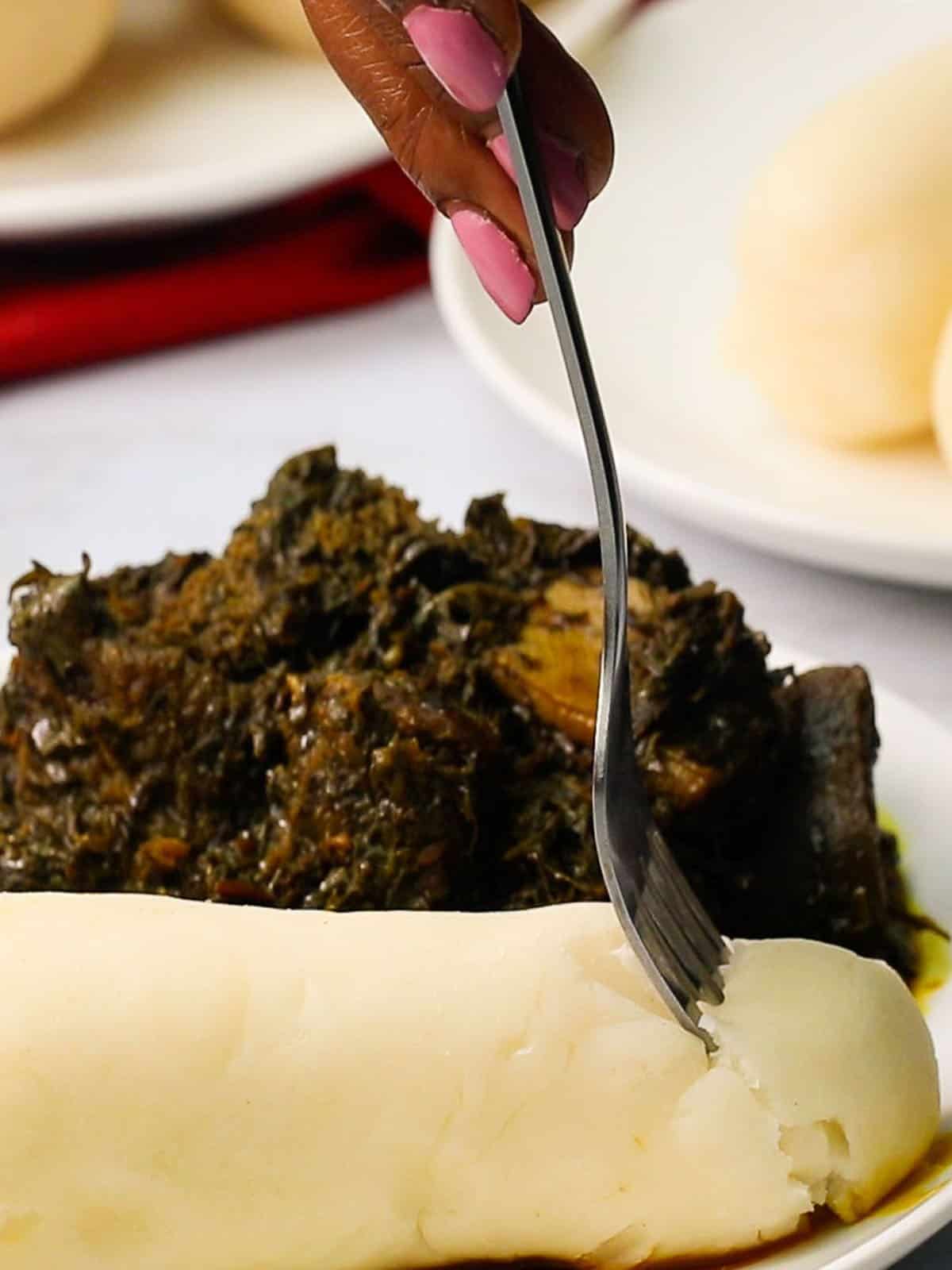 a forkful of cassava fufu or water fufu taken off the plate