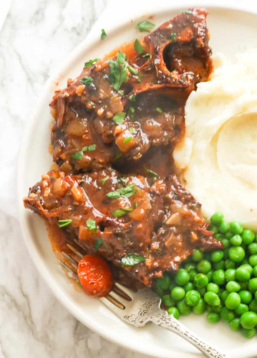 Braised Beef Neck Bones Served with Mashed Potatoes and Green Peas