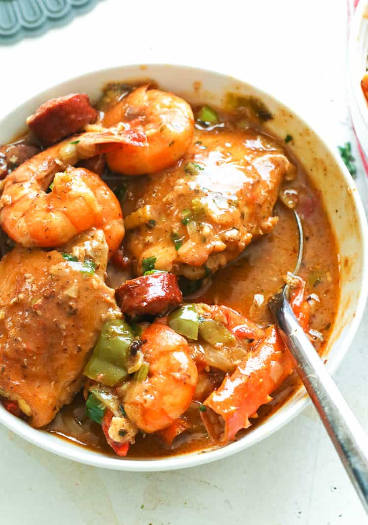 a bowl of gumbo dish with a spoon to scoop it out
