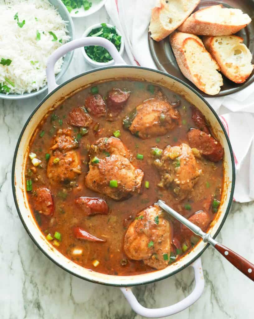 Finished pot of chicken and sausage gumbo with white rice and fresh bread