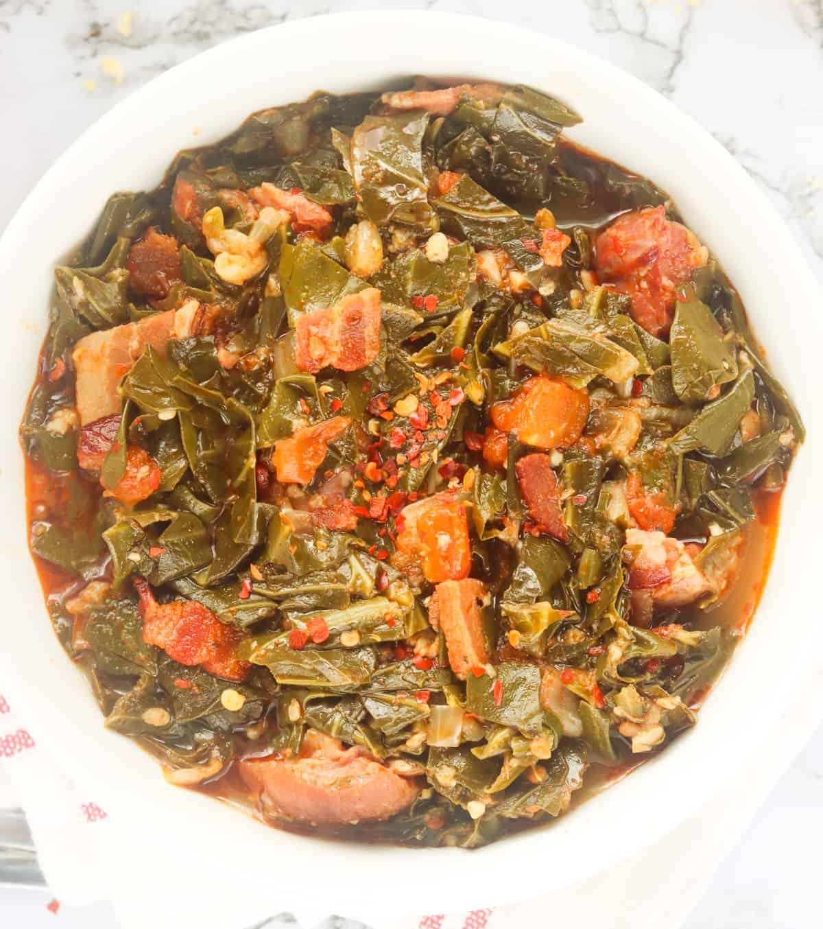 a big bowl of southern collard greens with ham hocks and bacon