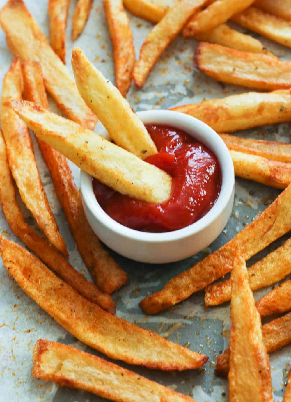 two seasoned fries dipped in ketchup