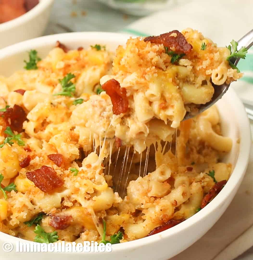 a bowl of cheesy gooey bacon mac and cheese being pulled out