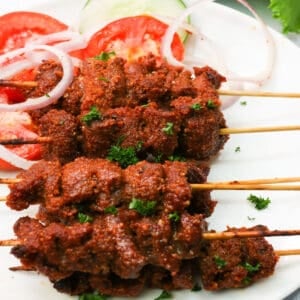 a plate of stacked suya beef