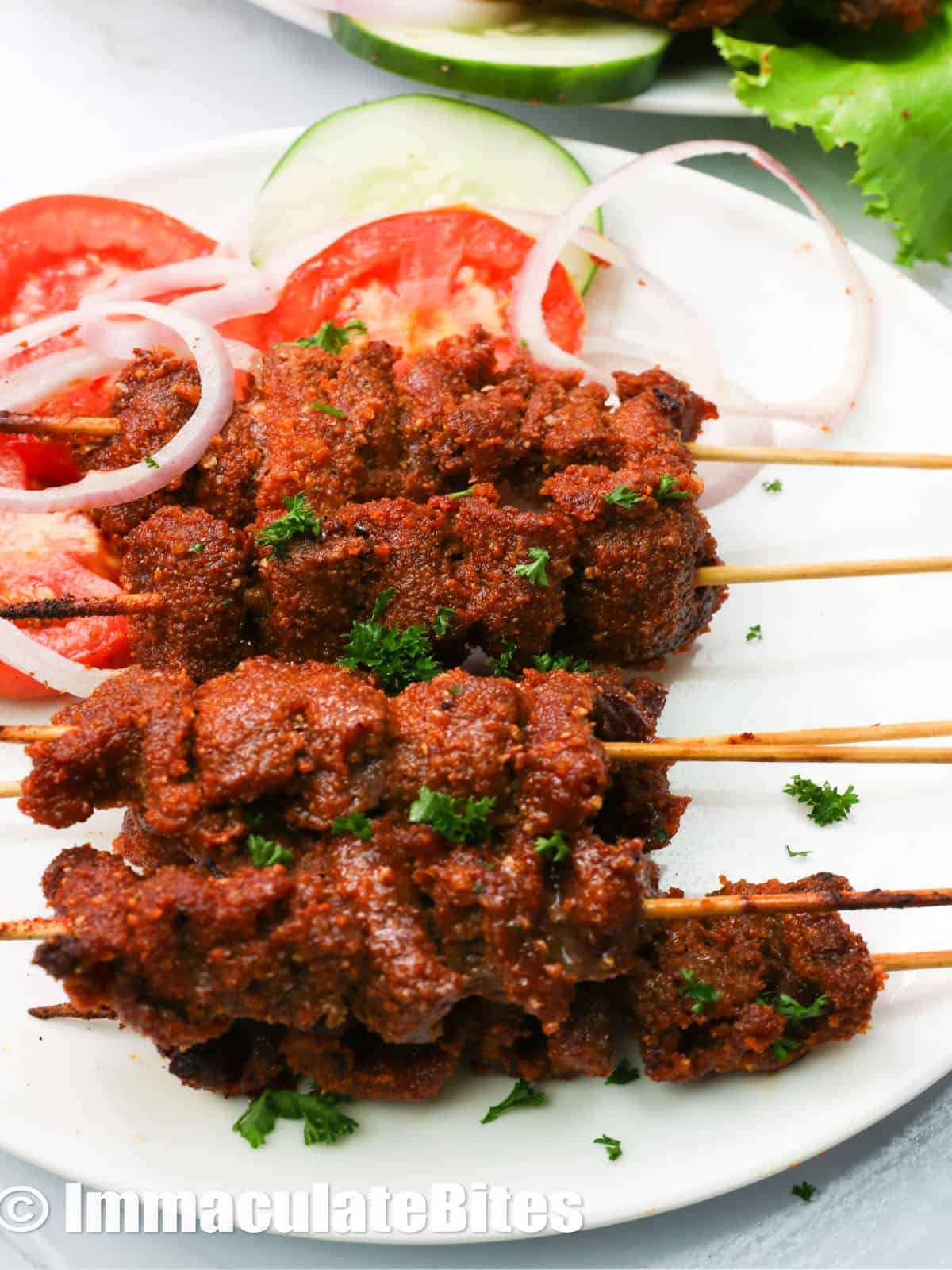 a plate of stacked suya beef on a skewer