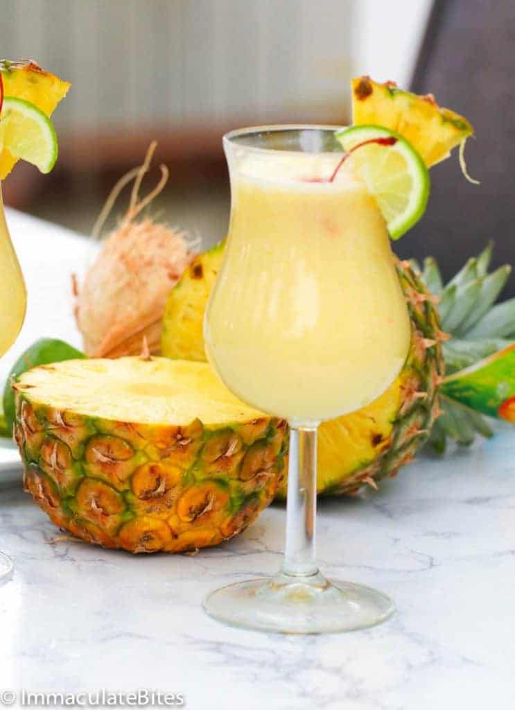 Pina Colada in a fancy glass with a cut pineapple in the background