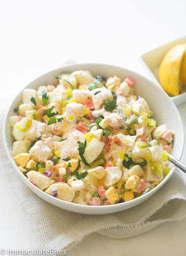 Caribbean Potato Salad with a lemon wedge is the perfect anytime side, especially for jerk chicken
