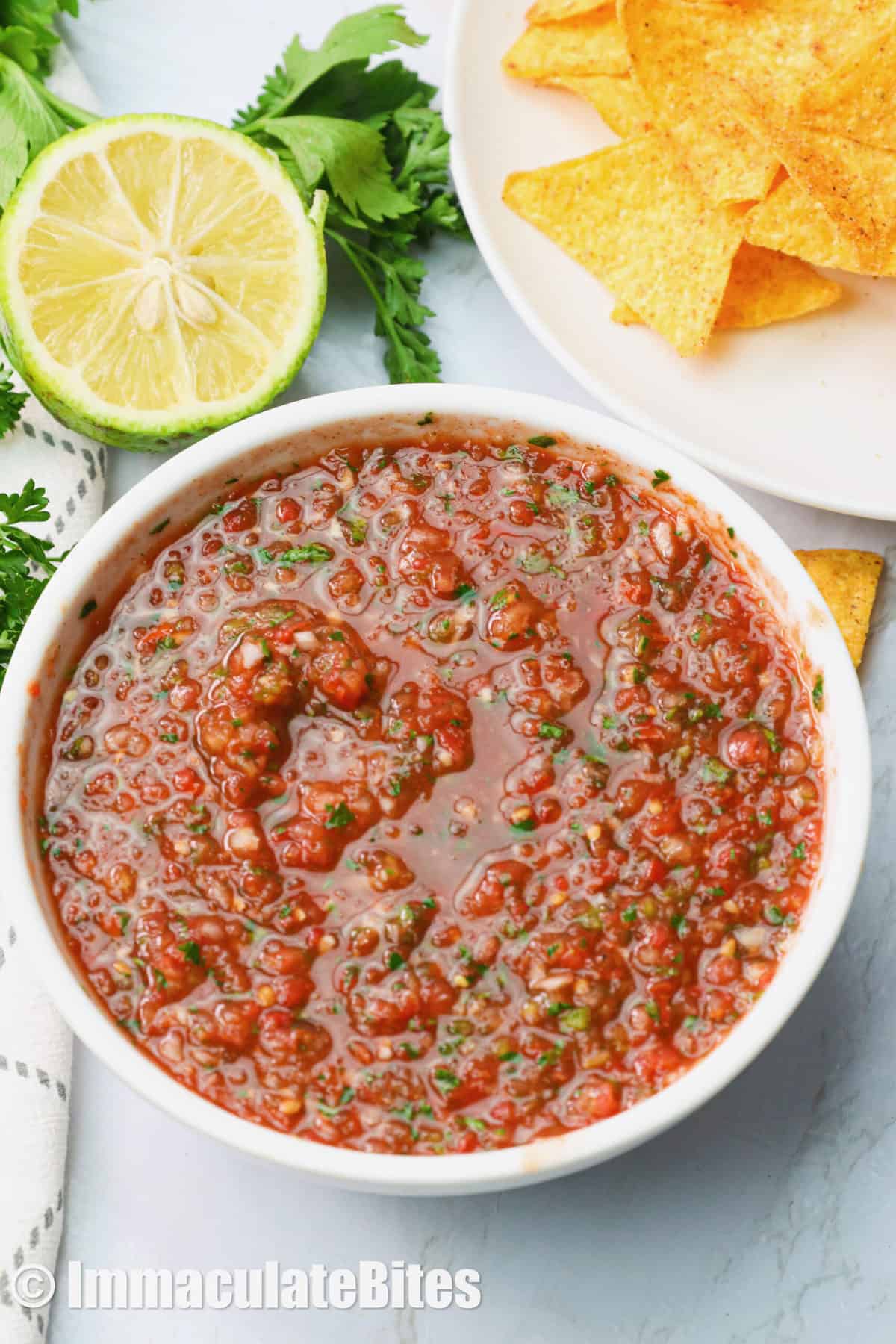 Restaurant-style salsa in a white bowl with homemade tortilla chips