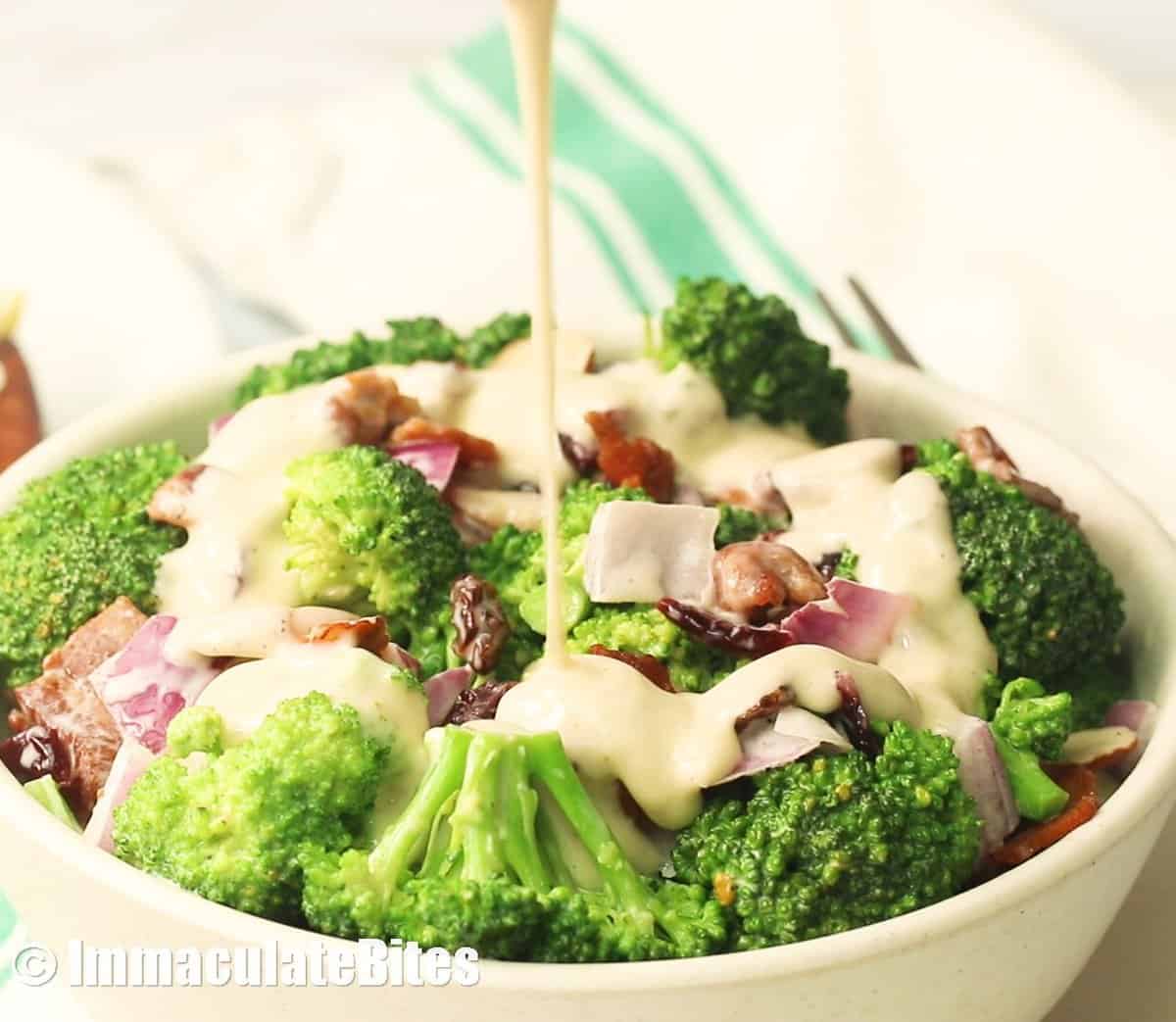 Drizzling salad dressing on the bacon and broccoli salad