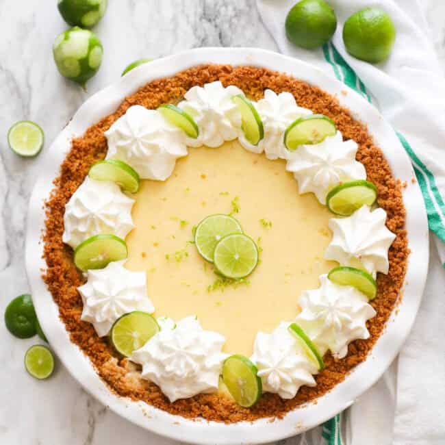 Key lime pie decorated with key lime slices and whipped cream