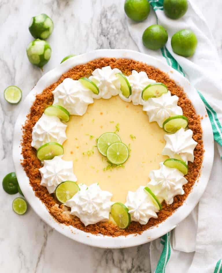 Key lime pie decorated with key lime slices and whipped cream