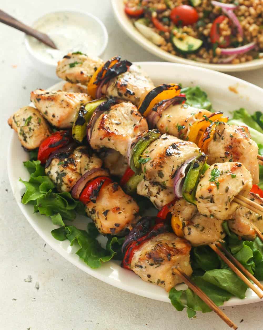 Chicken kabobs on a platter with couscous in the background