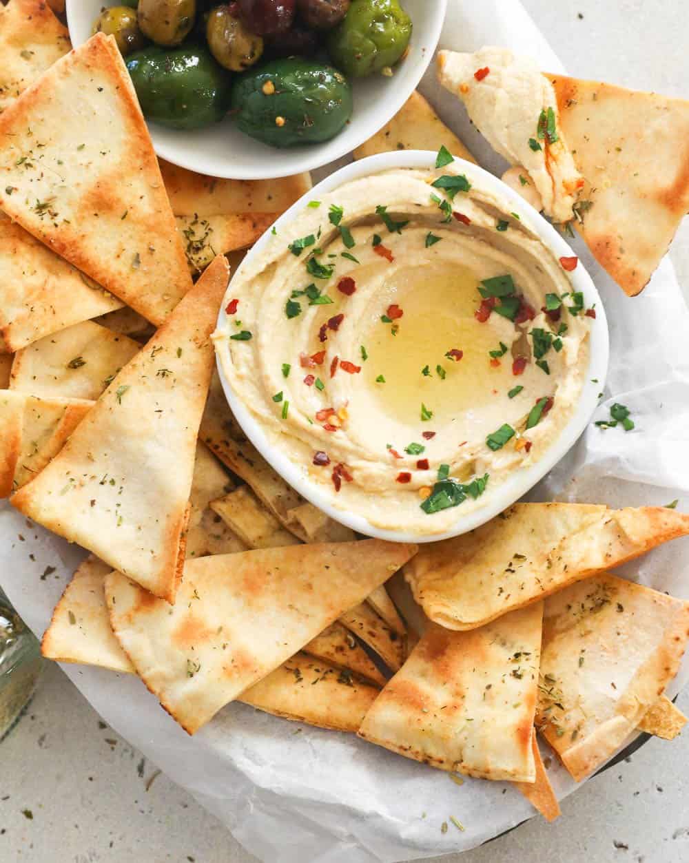 Pita chips with hummus and olives