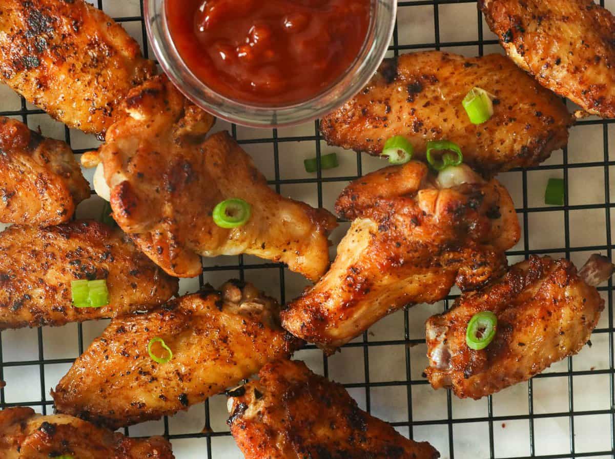 Grilled chicken wings with red sauce on the side