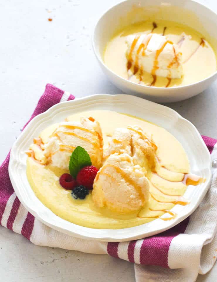 Floating Island dessert with fresh berries in a white bowl