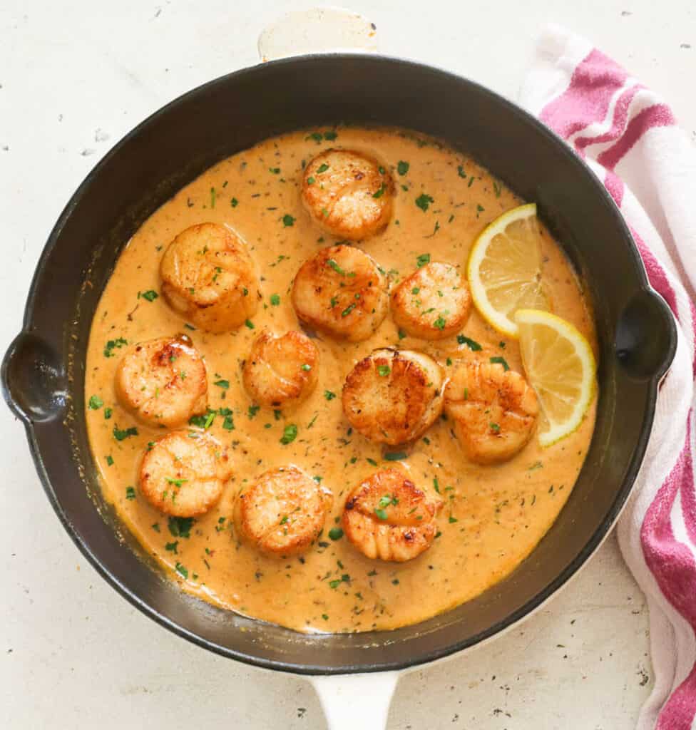 Creamy scallops hot in the pan with lemon slices